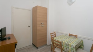 A room with a wooden wardrobe, a small table with a checkered tablecloth, a television, and a remote control. - N151 - Numana, delightful two-room apartment with porch (Numana)