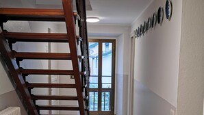 A staircase leading to a balcony with a view of the outside.