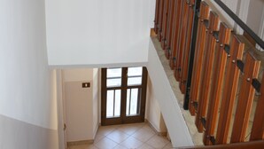 A staircase with wooden steps and metal railings, leading to a door with a window.