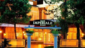 L'ingresso di un hotel con un cartello che recita 'hotel IMPERIALE' e un vialetto che conduce al palazzo.