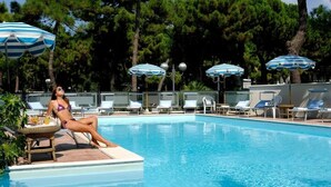Area piscina con lettini e ombrelloni.