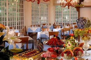 A dining area with tables set for a meal, large windows, and a chandelier. - Hotel Imperiale (Cervia)