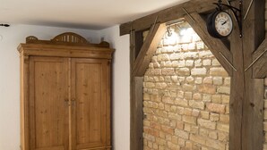 A wooden wardrobe and a stone wall with a clock. - Elizabetes Center Apartments (Riga)