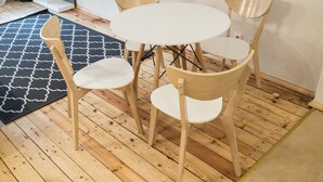 A room with a round wooden table and four chairs, a black and white patterned rug, and wooden flooring. - Elizabetes Center Apartments (Riga)