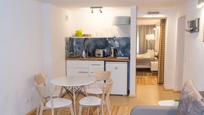 A compact living space with a kitchenette, dining area, and a bedroom. - Elizabetes Center Apartments (Riga)