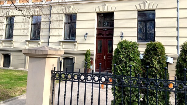 A multi-story building with a classic architectural style, featuring a prominent entrance with a dark red door and a number '9' above it. - Elizabetes Center Apartments (Riga)