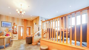 A hotel lobby with a reception desk, a staircase, and a view of the city. - Standing Stones Lodge (Belfast)