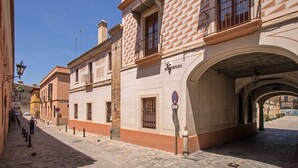 Un carrer empedrat amb edificis històrics, un cartell que diu 'MAÑENZO' i un senyalitzador de prohibició d'estacionar.