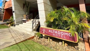L’extérieur de l’hôtel Altadomo se distingue par son entrée imposante, les marches menant à l’entrée et une enseigne.