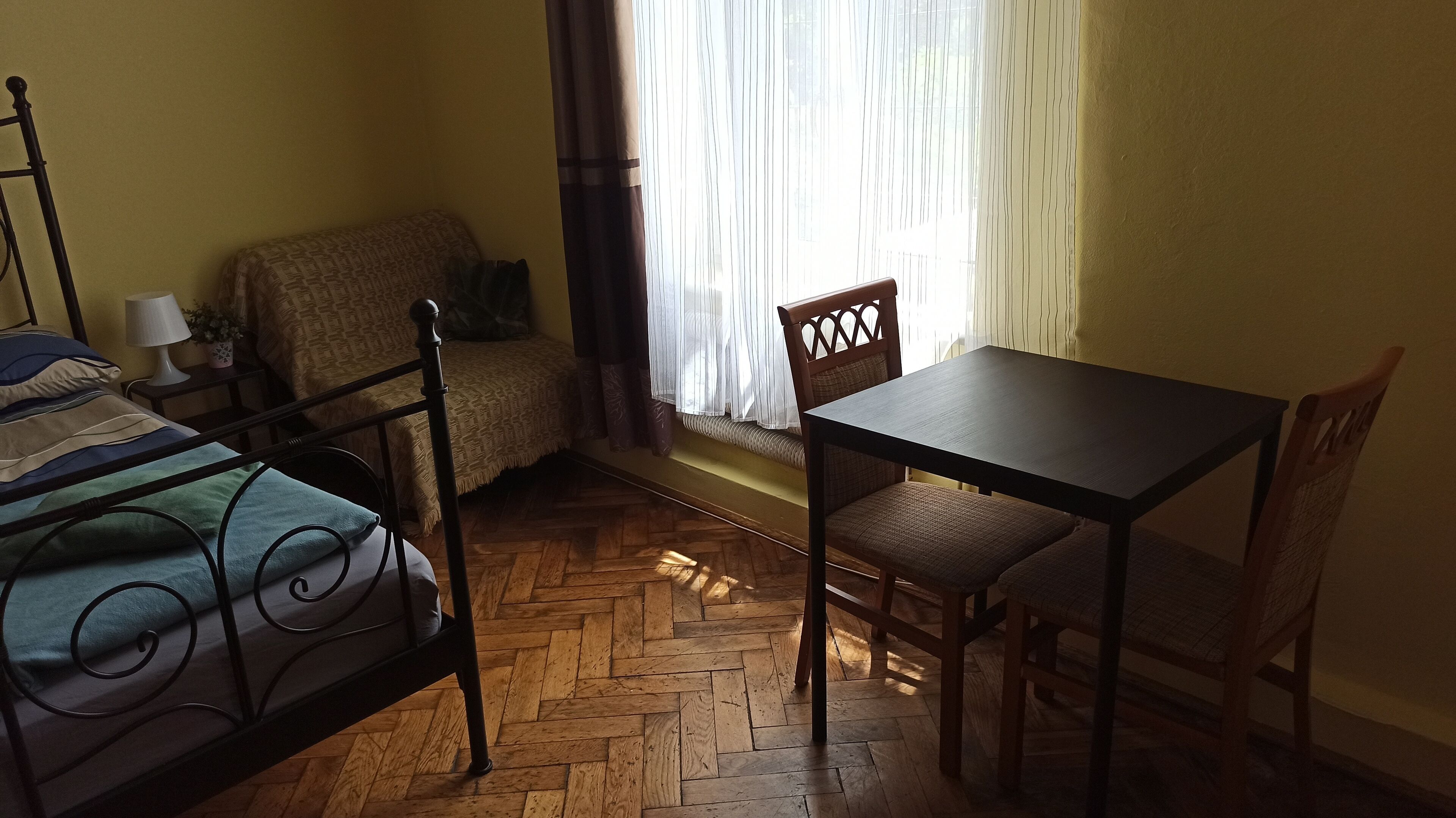 Un dormitorio con cama, mesa y silla.
