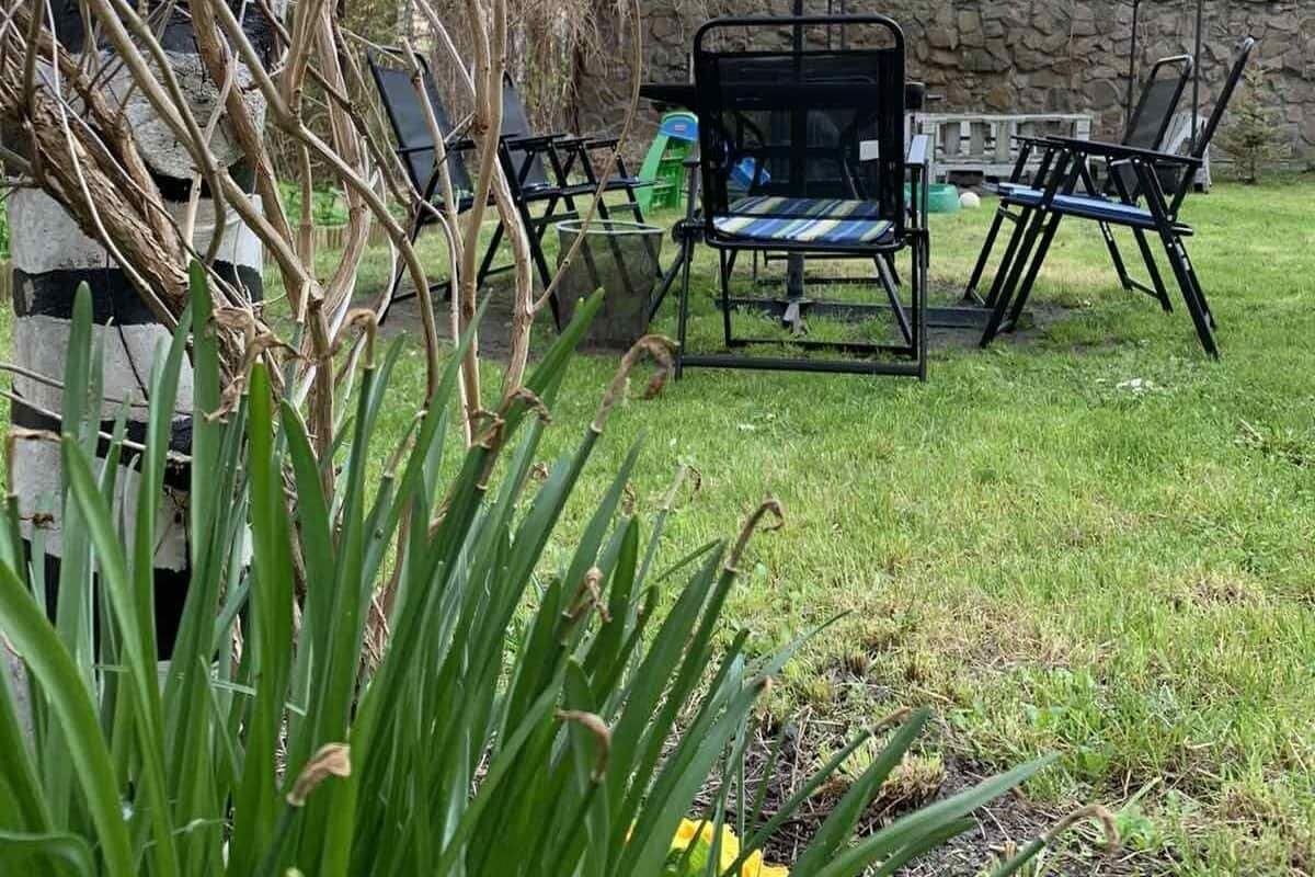 Ein möblierter Patio-Bereich im Freien mit schwarzem Sonnenschirm, Tisch und Stühlen.