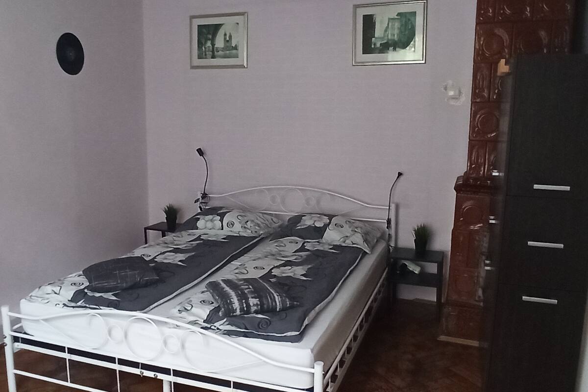 Ein Schlafzimmer mit einem Bett, zwei Nachttischen, einer Kommode und zwei gerahmten Bildern an der Wand.