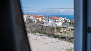 A coastal town with buildings, a railway track, and a clear view of the sea and mountains in the distance. - Apartment for 4 person (Vrbnik)
