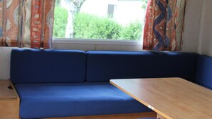 Una habitación con un sofá azul y una mesa de madera.