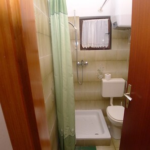 A small bathroom with a shower, toilet, and a towel rack. - Holiday Apartment Near the Beach for 4 Persons With one Bedroom (Medulin)