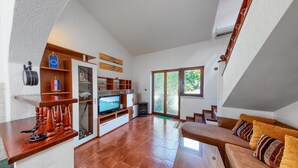 A spacious living room with a fireplace, a television, and a sofa.