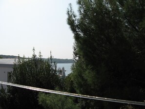 A view of a body of water with a building and trees in the foreground. - Six Person Apartment With 2 Bedrooms Near the Beach in Pjescana Uvala (Medulin)