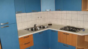 A kitchen with blue cabinets, a stainless steel sink, and a gas stove. - Six Person Apartment With 2 Bedrooms Near the Beach in Pjescana Uvala (Medulin)