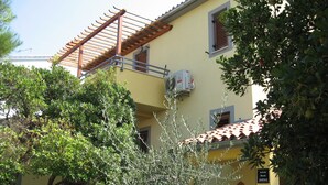 A yellow building with a tiled roof, an air conditioning unit, and a sign indicating it is an apartment. - Six Person Apartment With 2 Bedrooms Near the Beach in Pjescana Uvala (Medulin)