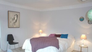Ein Schlafzimmer mit einem Bett, zwei Nachttischlampen, einem Sessel und einem Wandglobus.