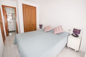 A bedroom with a bed, two bedside tables, a wardrobe, and a bathroom visible through an open door. - A18 APOLO 7 ESC 1 4º 54 (Calpe)