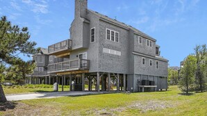 Une maison à deux étages avec un balcon, une cheminée et une véranda couverte.