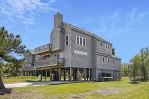 Une maison à deux étages avec un balcon, une cheminée et une véranda couverte.