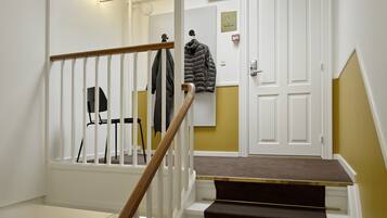 Un escalier avec une rampe en bois et une porte blanche en haut.