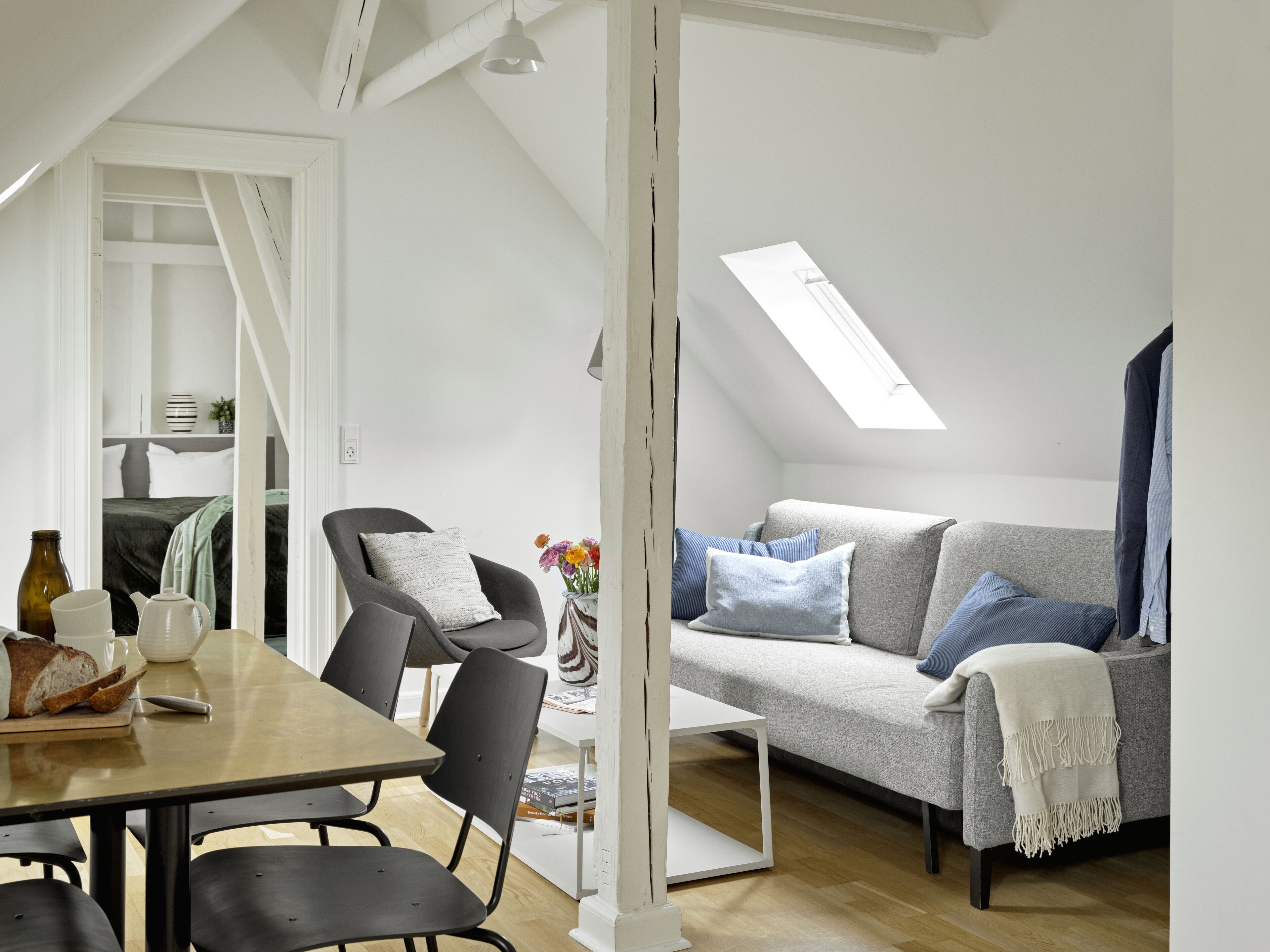 Un loft moderno con comedor, sofá y tragaluz.