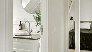 Un baño moderno con lavamanos, espejo y artículos de aseo.