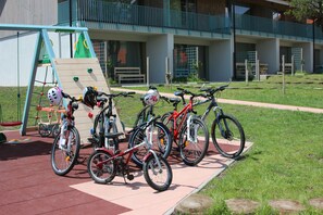 Bicycles parked near a climbing wall and a building with a balcony. - Penzión Čerešnový Sad (Mengusovce)