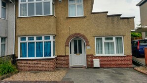 A two-story house with a brick facade, a white door, and a small garden area in front. - Filton House (Bristol)