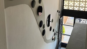 A modern interior with a unique wall design featuring circular and oval shapes. - Beit Mirna Guesthouse & Chalet (Ehden)
