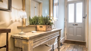 A wooden console table with a potted plant, a lamp, and a small decorative item. - April House Weybridge - Boutique Guesthouse (Weybridge)