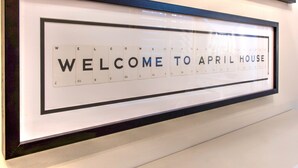 A framed welcome sign with the text "WELCOME TO APRIL HOUSE" and a calendar below it. - April House Weybridge - Boutique Guesthouse (Weybridge)