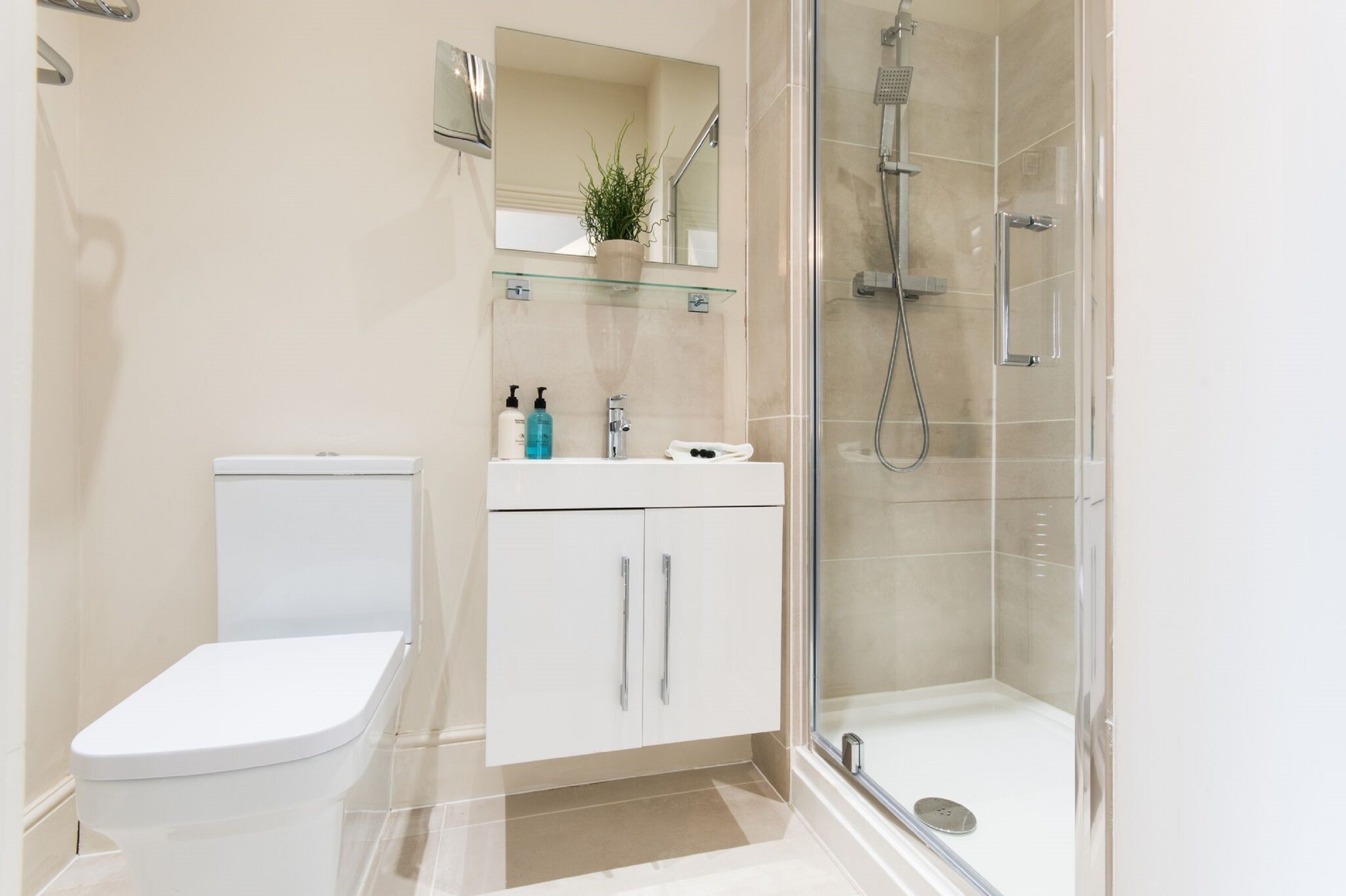 Un baño moderno con inodoro, lavamanos y ducha.