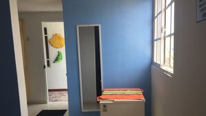 A hallway with a blue wall, a white door, and a small white cabinet with a colorful towel. - Bluehouse backpackers club, hostel excelente ubicación buen precio San Andrés I (San Andrés)