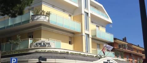 Un hotel con diseño moderno, que presenta un cartel llamativo de 'ROYAL', un letrero de estacionamiento y un cartel de 'No Entrar'.