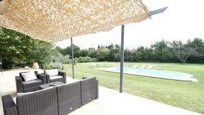 An outdoor patio with wicker furniture, a pool, and a decorative canopy. - Vacation rental house with pool MOURIES LS1-343 (Mouriès)