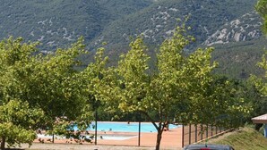 Poolbereich mit Blick auf Berge, umgeben von Bäumen.