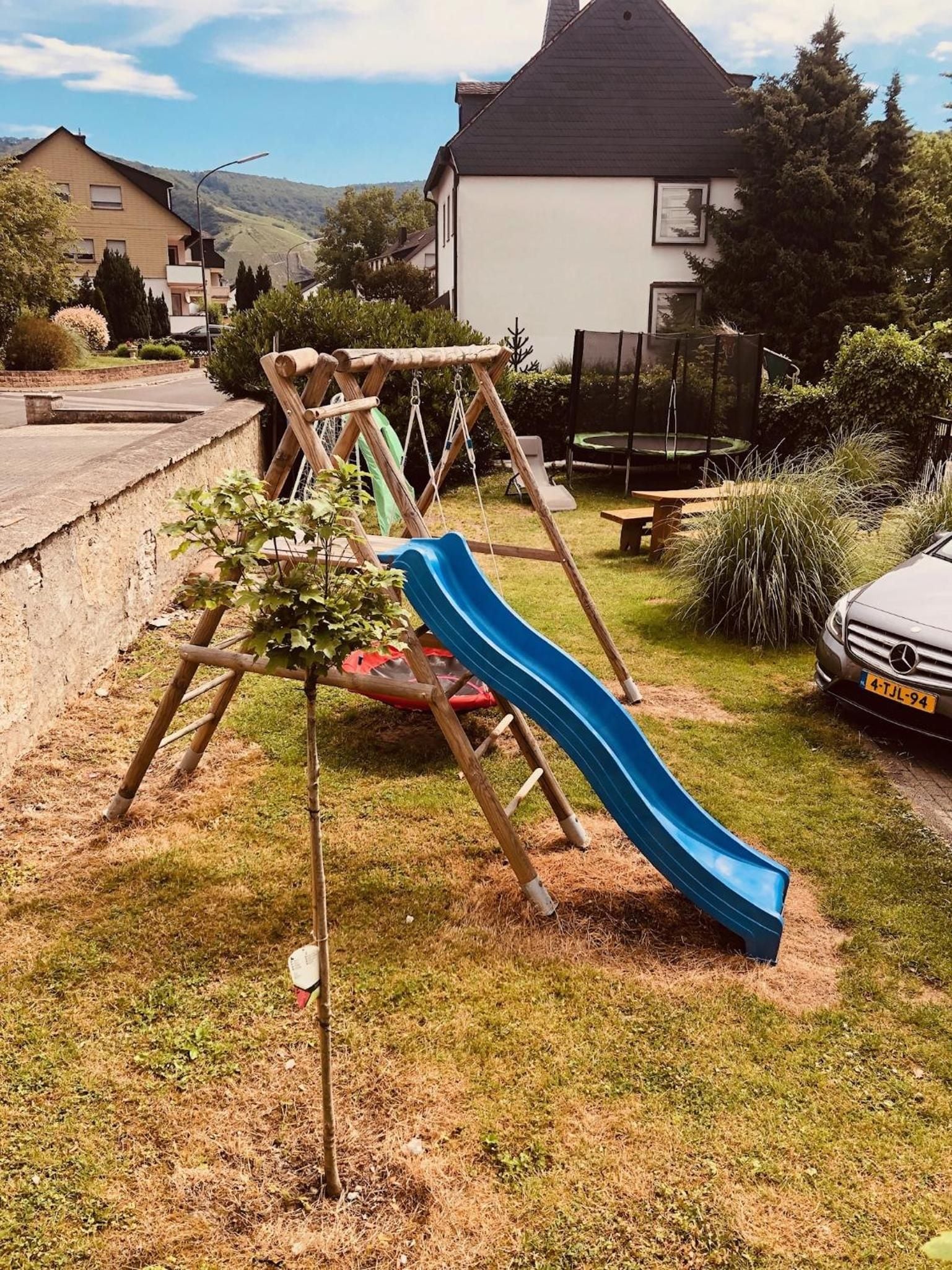 A playground with a slide and swings in a residential area.