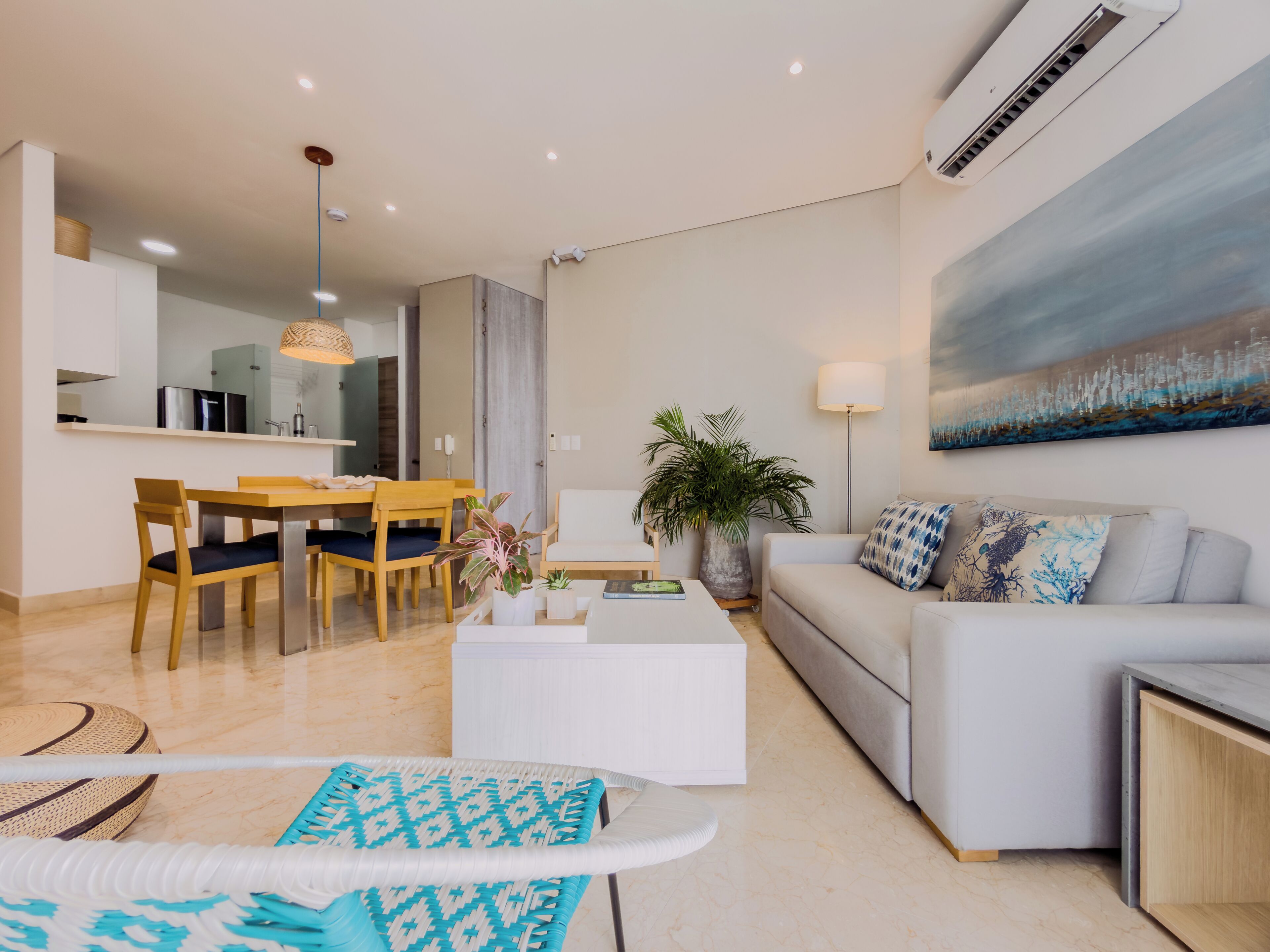 A modern living room with a sofa, coffee table, and dining area.