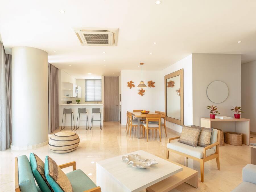 A modern living room with a sofa, coffee table, and dining area.