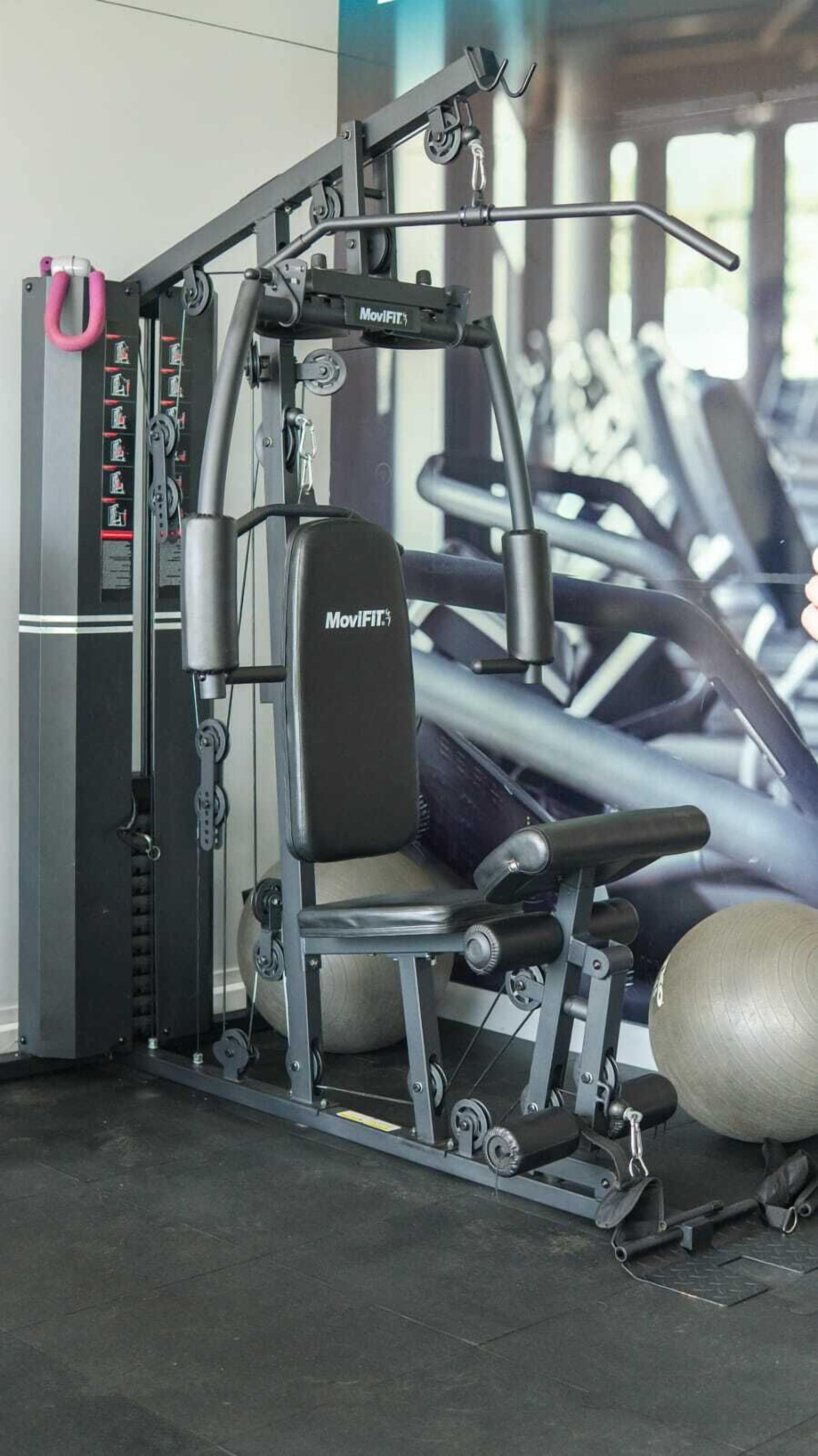 Un appareil de musculation MovFIT doté d’une pile de poids, de poulies réglables et d’un siège rembourré.