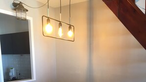 A dining area with a white table and two chairs, a hanging light fixture above, and patterned floor tiles. - 47m2 duplex apartment - type 2 with terrace (Frejus)