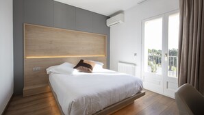 Ein modernes Schlafzimmer mit einem Holzkopfende, einem großen Fenster mit Vorhängen und Blick ins Freie.
