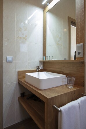 A modern bathroom with a wooden vanity, white sink, and a mirror above it. - Hostal Rural Can Pau (Cantallops)