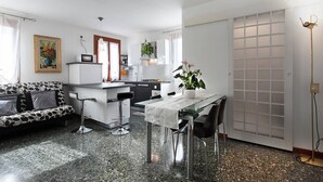 A compact living space with a kitchenette, a dining area, and a sofa. - Grimaldi Apartments - Ca Sole (Venice)