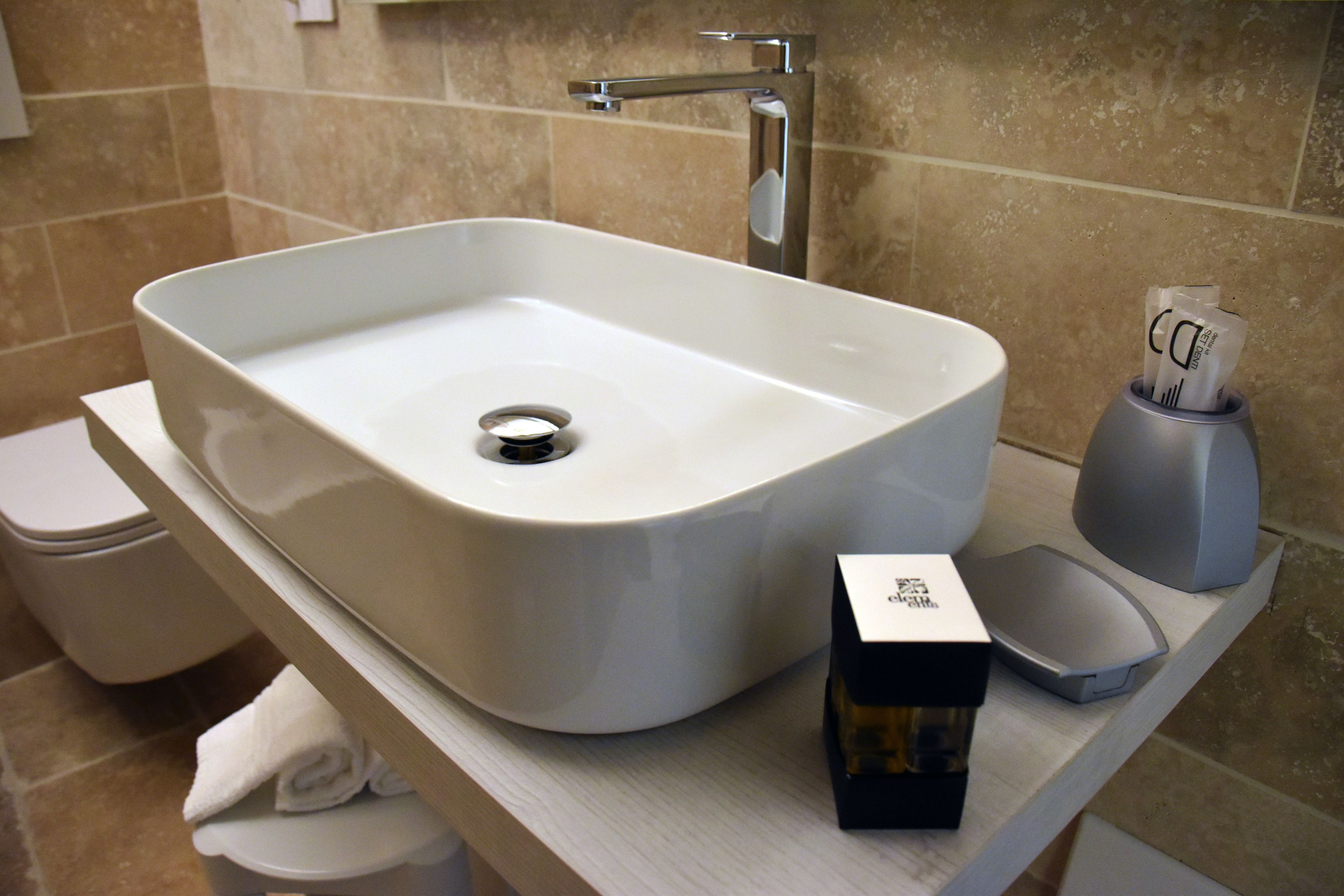 Un baño con un lavamanos blanco, inodoro y un perchero para toallas.
