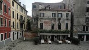 Une cour dallée de pierres, entourée d’immeubles à plusieurs étages dotés de balcons et de fenêtres.